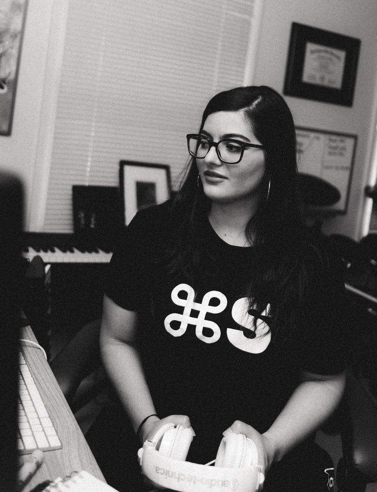 Woman sits in recording studio wearing black command s tee